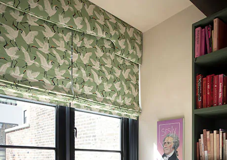 Cordless Roman Shades made of Novogratz Family of Cranes in Waverly Green adds color and pattern to a sitting room