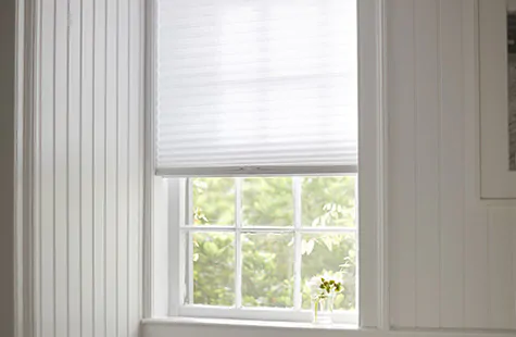A small window has a light filtering Cellular Shade made of 3-4 Single Cell material in Lace for a soft, subtle look