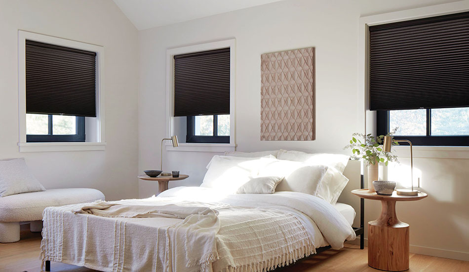 A contemporary style bedroom has soft white tones and Cellular Shades made of 3-4 Single Cell Blackout in Midnight