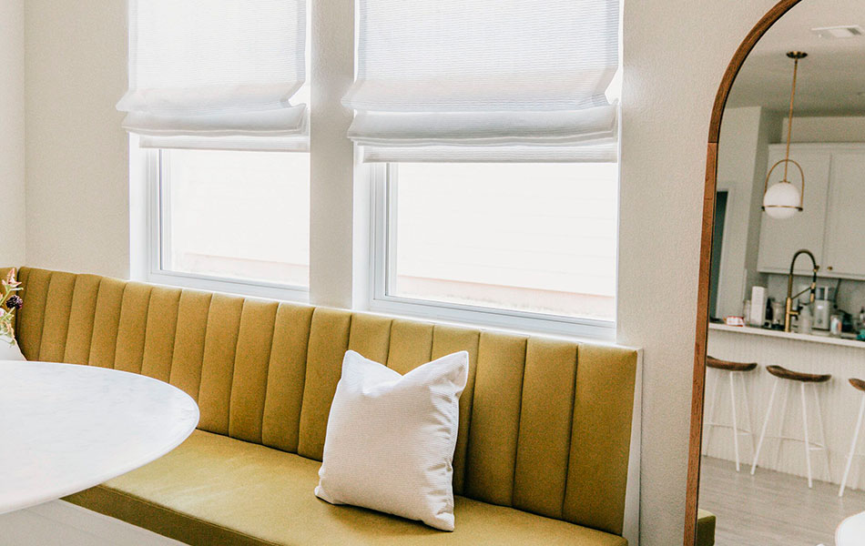 Flat Roman Shades made of Tangier Weave in Blanco are one of the window seat ideas paired with a plush yellow bench