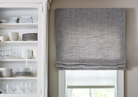 Cordless Roman Shades made of Shoreline in Pewter add color and texture to a kitchen with white cabinets