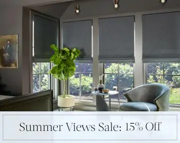 Flat Roman Shades of Wool Blend, Charcoal cover bedroom windows with overlaid sales messaging for Summer Views Sale: 15% Off