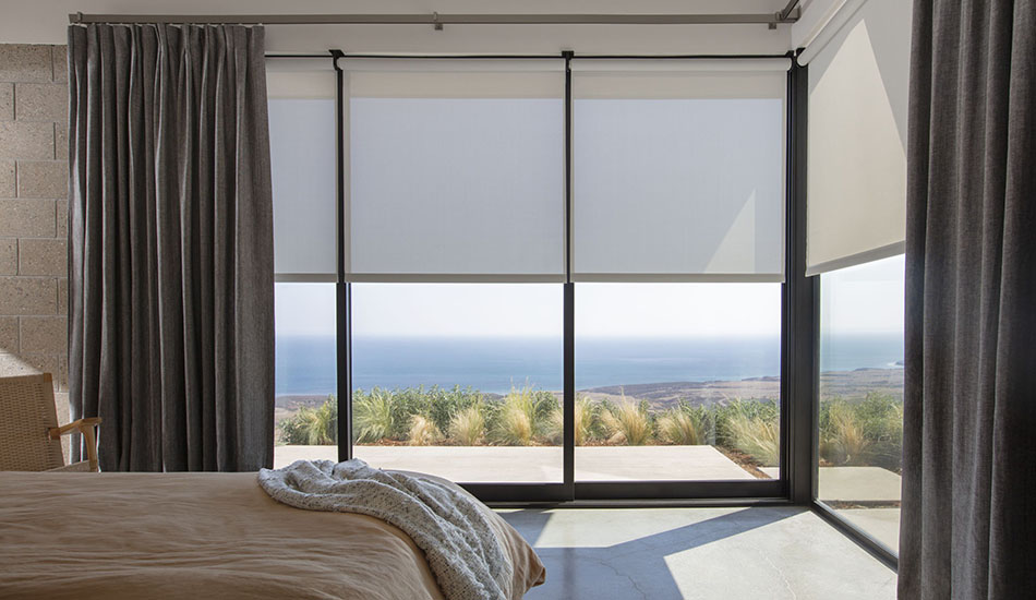 Bedroom window treatment ideas for a modern beach house include Inverted Pleat Drapery in Herringbone, Onyx, and Solar Shades