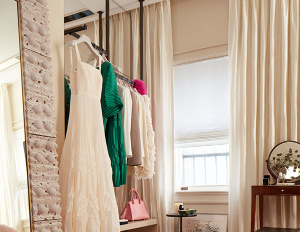 A dressing room has neutral curtains made of Silk Dupioni in Ivory for an elegant touch that elevates the space