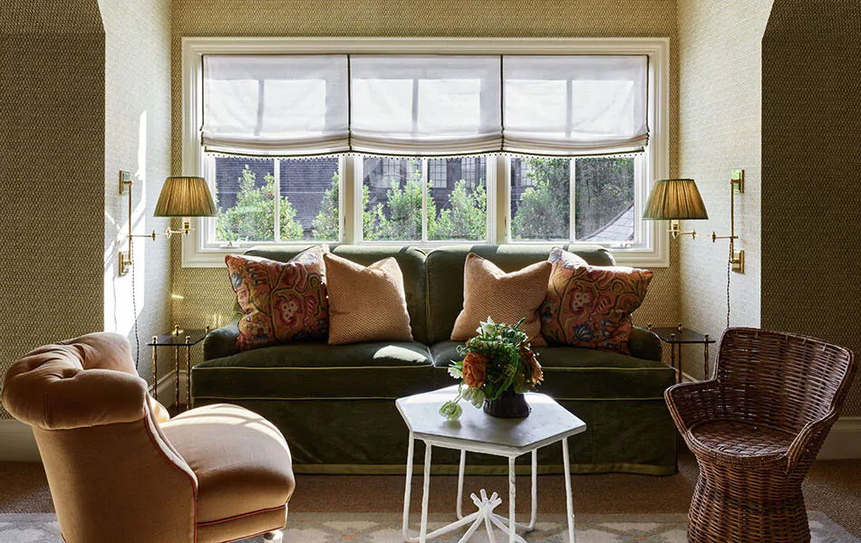 A cozy loveseat is used for window seat ideas that also include Relaxed Roman Shades made of Sheer Wool Blend in Cloud