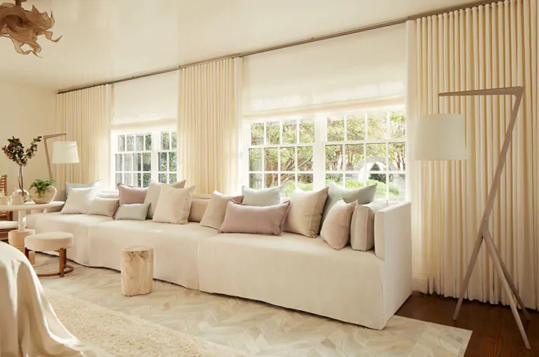 Neutral curtains made of Ripple Fold Drapery in Heathered Linen in Ivory blend into the warm creamy colors of a living room