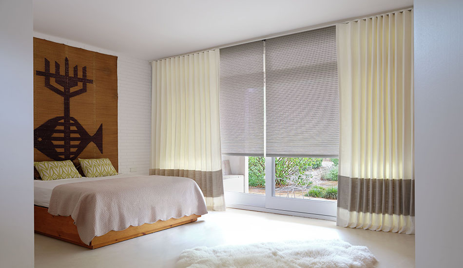 Bedroom window treatment ideas for a boho chic style include Ripple Fold Drapery of Luxe Linen & Roller Shades in Mesa Verde