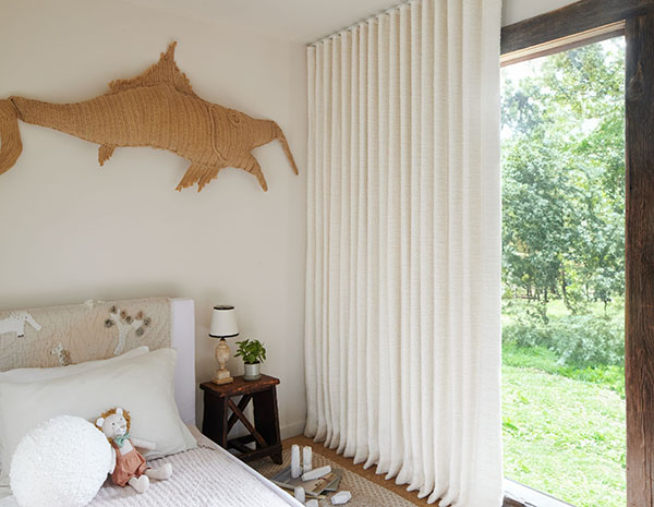Neutral curtains made of Nate Berkus Claude Stripe in Alabaster offer a soft inviting look to a kids bedroom