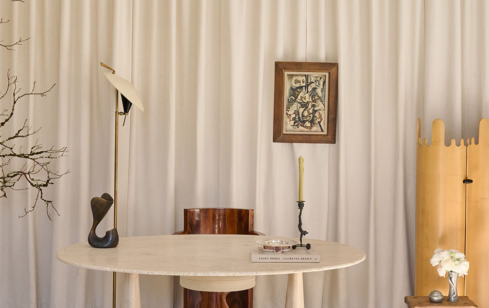 A marble desk and wood chair sit in front of home office curtains made of Lowell Tweed in Ivory for a lush, inviting look