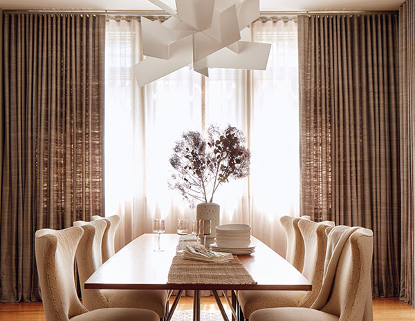 An elegant dining room has two layers of neutral curtains in Raw Silk, Graphite and Luxe Sheer Linen, Natural for dimension