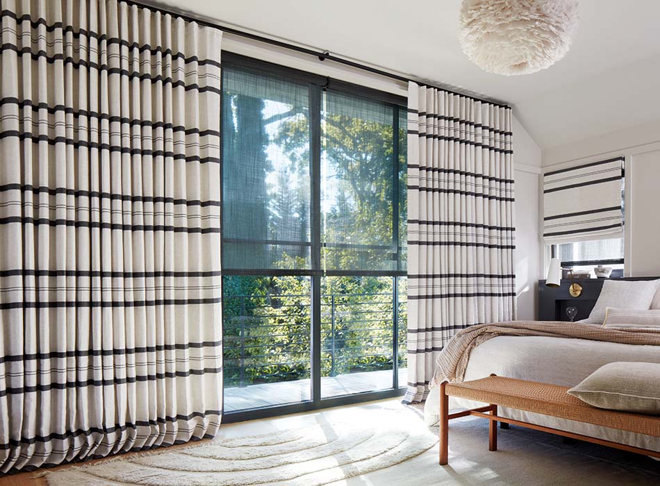 Sliding glass door curtain ideas include Ripple Fold Drapery made of Shoreham Stripe in Jet for a bold stripe in a bedroom