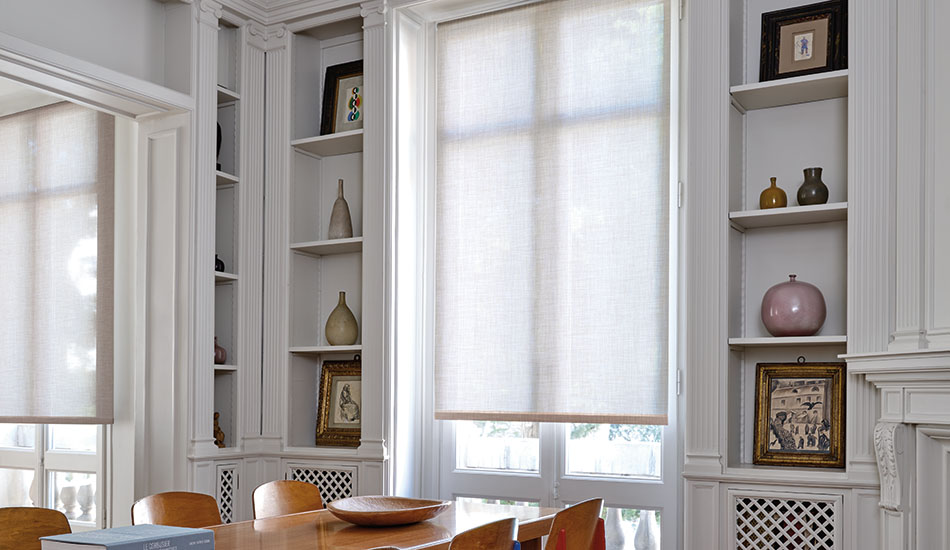 A mid-century modern dining room has French doors covered by a Roller Shade made of Techno in Linen for a soft look