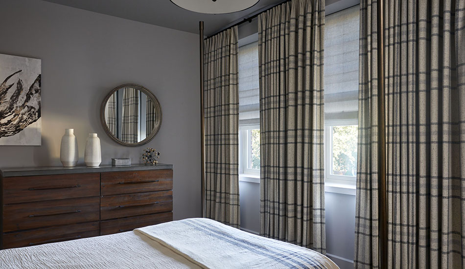 Bedroom window treatment ideas for a simple bedroom include Tailored Pleat Drapery in Aberdeen Fog with textured Roman Shades