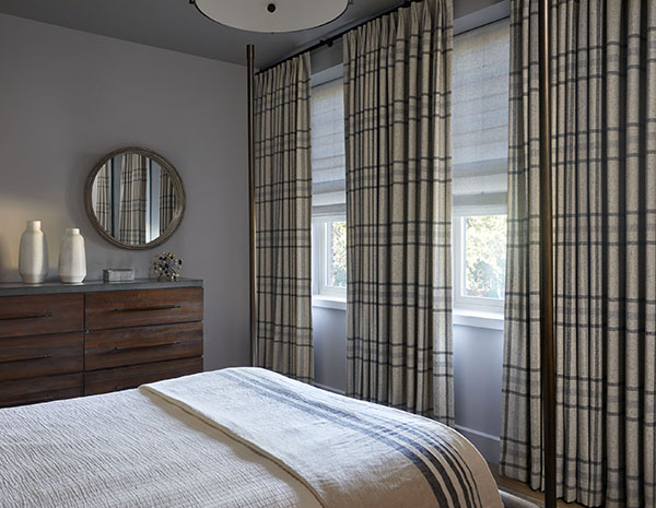 Neutral curtains made of Aberdeen in Fog add warmth to a cool grey bedroom with their thick, plaid pattern and soft colors