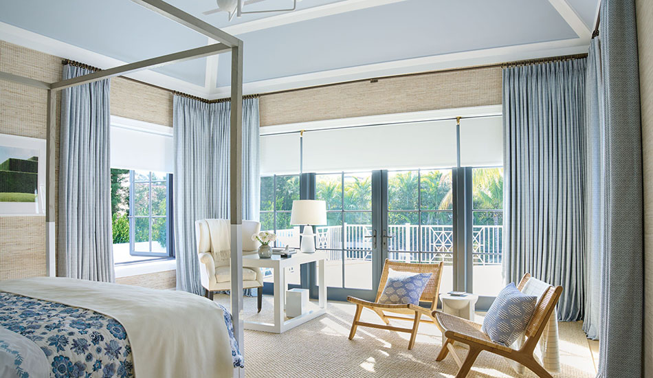 Bedroom window treatment ideas for a coastal style include Tailored Pleat Drapery in Vanda, Sky, and white Roller Shades