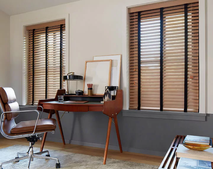 An office with a wooden desk and windows dressed with Oak Wood Blinds.